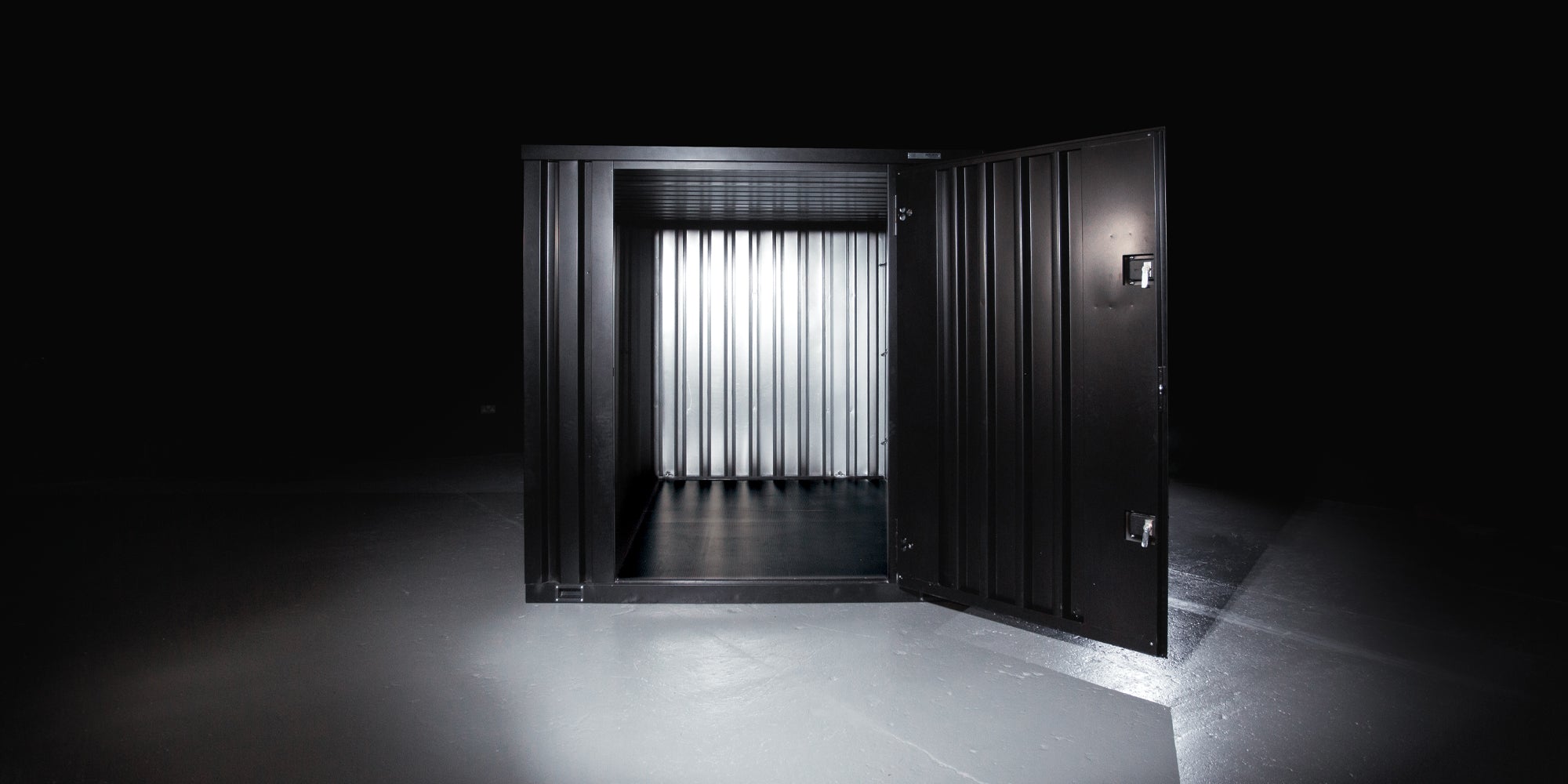 Black SiteStore with door open in a dark room with light shining on it.